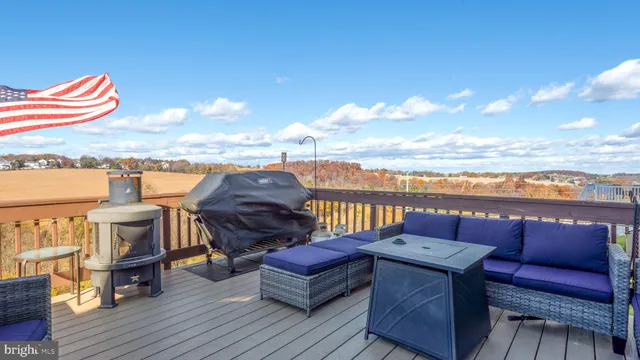a view of a roof deck with couches and wooden floor