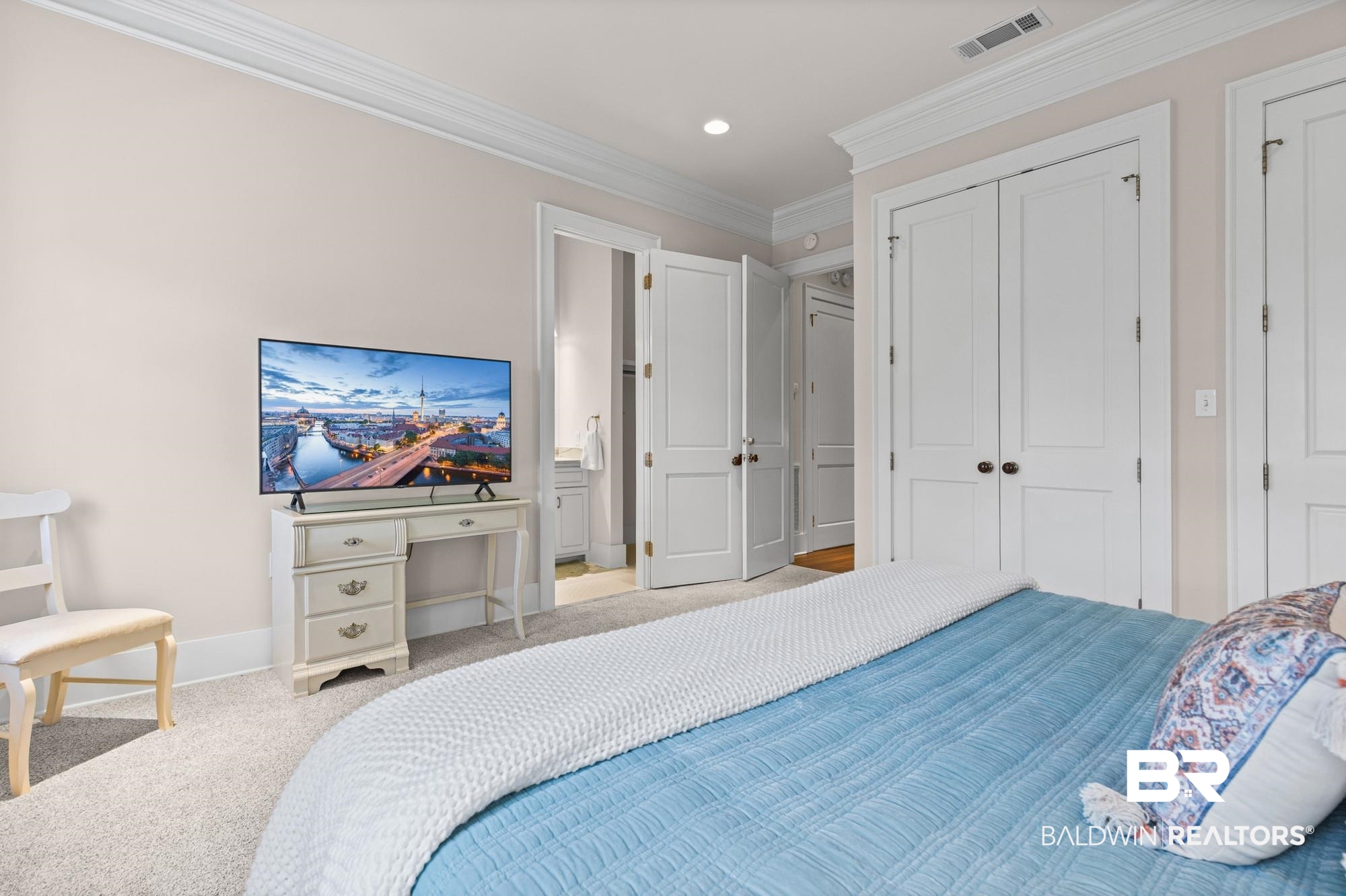 701 Dauphin Street, Unit A Mobile, AL 36602 - Photo 22 of 31 Bedroom featuring neutral wall tones, crown molding, double bi-fold closet doors, and light-colored carpeting
