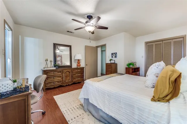 a bedroom with a bed dresser and wooden floor