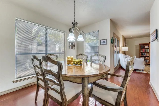 a dining room with furniture a chandelier and wooden floor