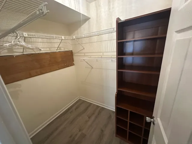 a view of walk in closet with empty racks