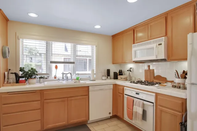 a kitchen with a sink stove cabinets and wooden floor