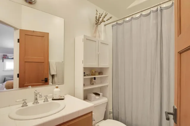a bathroom with a sink a toilet and shower curtain