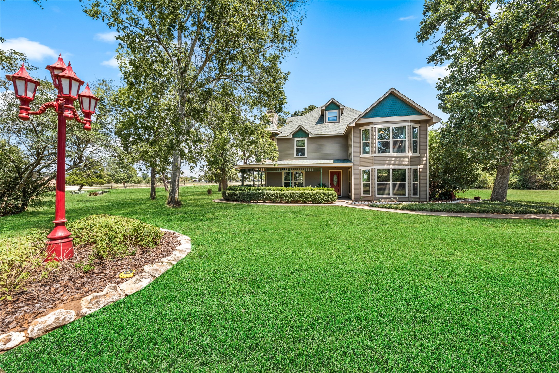 25948 Nelson Road Hempstead, TX 77445 - Photo 39 of 46 Expansive manicured lawn accented by mature shade trees and colorful landscaping, creating an impressive approach to the home.