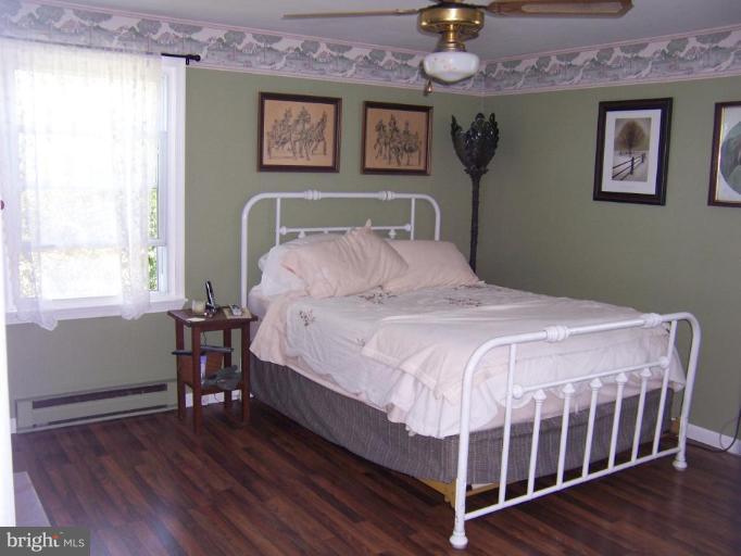 6843 Old Solomons Island Road Friendship, MD 20736 - Photo 11 of 20 a bedroom with a bed and wooden floor