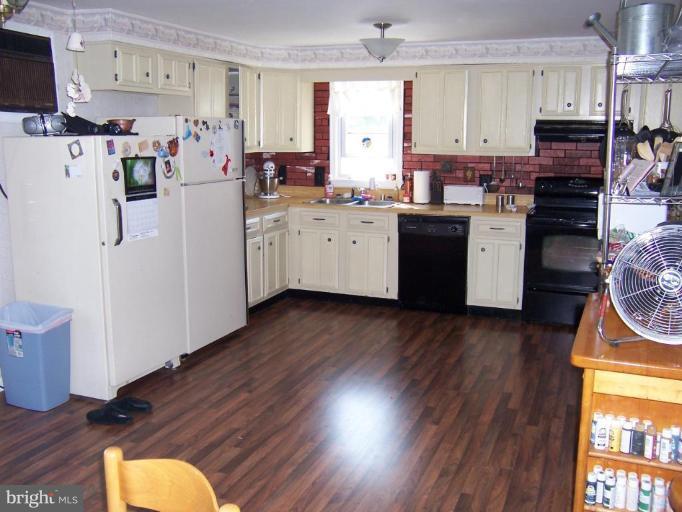6843 Old Solomons Island Road Friendship, MD 20736 - Photo 9 of 20 a kitchen with a refrigerator a stove a sink dishwasher and wooden cabinets