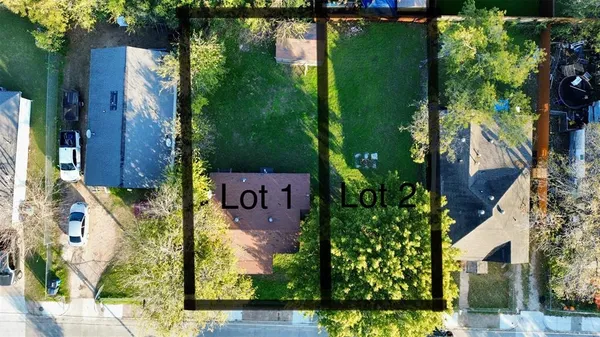 an aerial view of a residential houses with outdoor space and trees