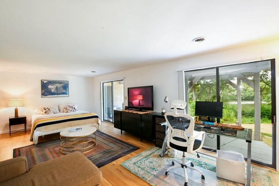 38 Landfall, Unit 38 Falmouth, MA 02540 - Photo 12 of 17 a living room with furniture a flat screen tv and a large window