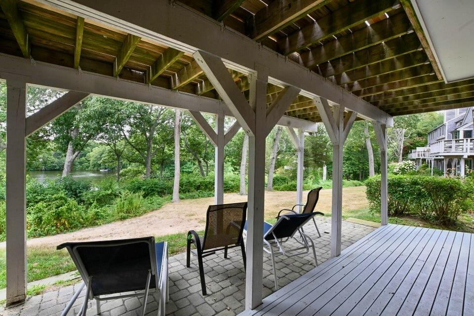 38 Landfall, Unit 38 Falmouth, MA 02540 - Photo 16 of 17 a view of a patio with table and chairs potted plants with wooden floor and fence