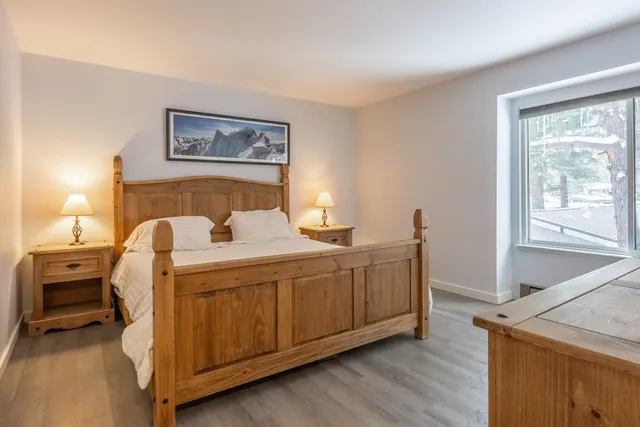 a bedroom with a bed and wooden floor