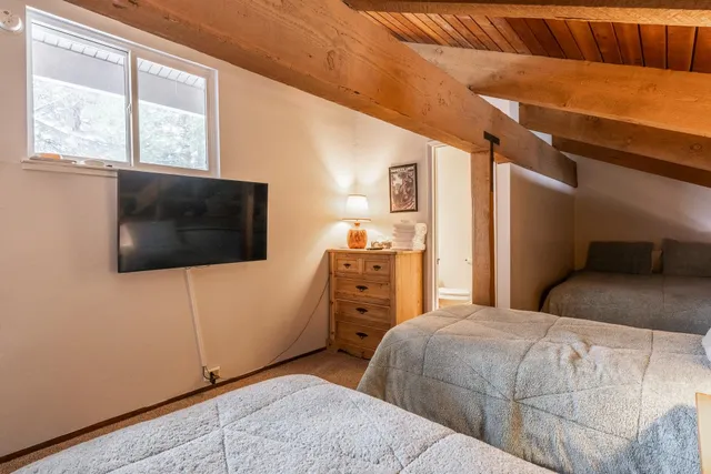 a bedroom with a bed and a flat tv screen on dresser