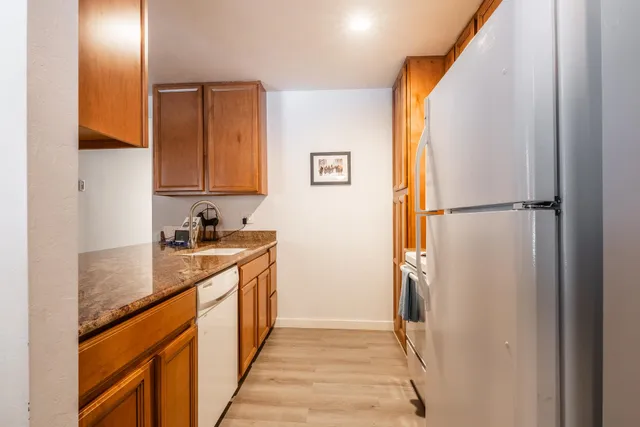 a kitchen with stainless steel appliances granite countertop a refrigerator and a sink