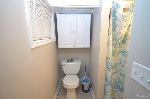 a bathroom with a toilet and a shower curtain