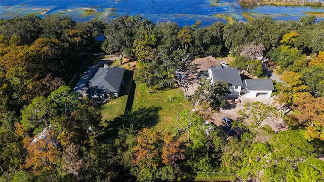 an aerial view of residential houses with outdoor space and trees