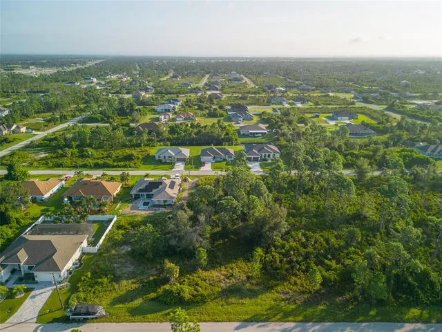 an aerial view of residential houses with outdoor space and trees