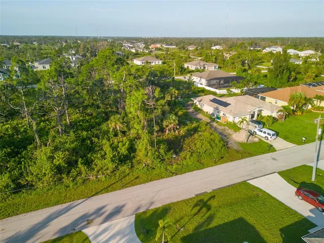 an aerial view of residential houses with outdoor space and trees