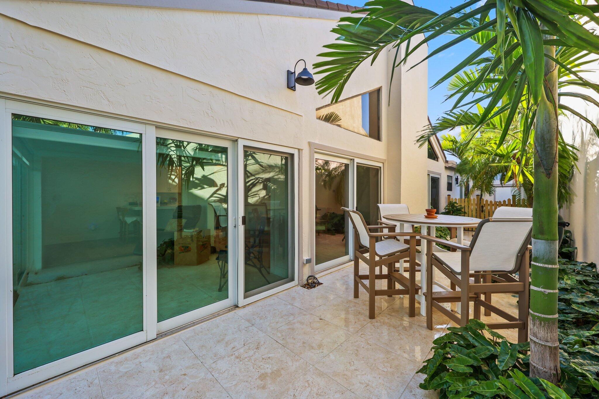 17012 Traverse Circle Jupiter, FL 33477 - Photo 19 of 33 a patio with yard glass top table and chairs