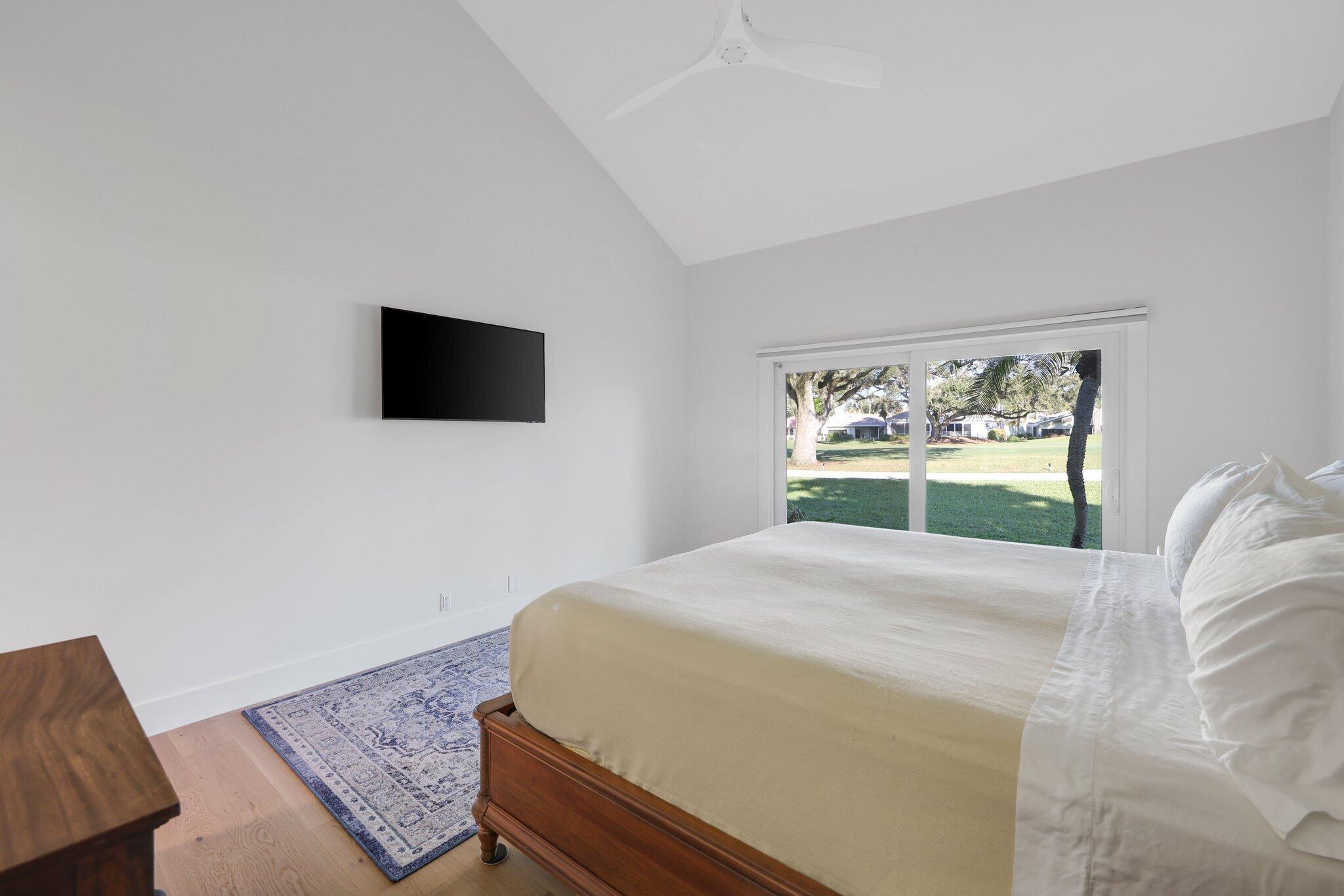 17012 Traverse Circle Jupiter, FL 33477 - Photo 30 of 33 a bedroom with a bed and a flat screen tv