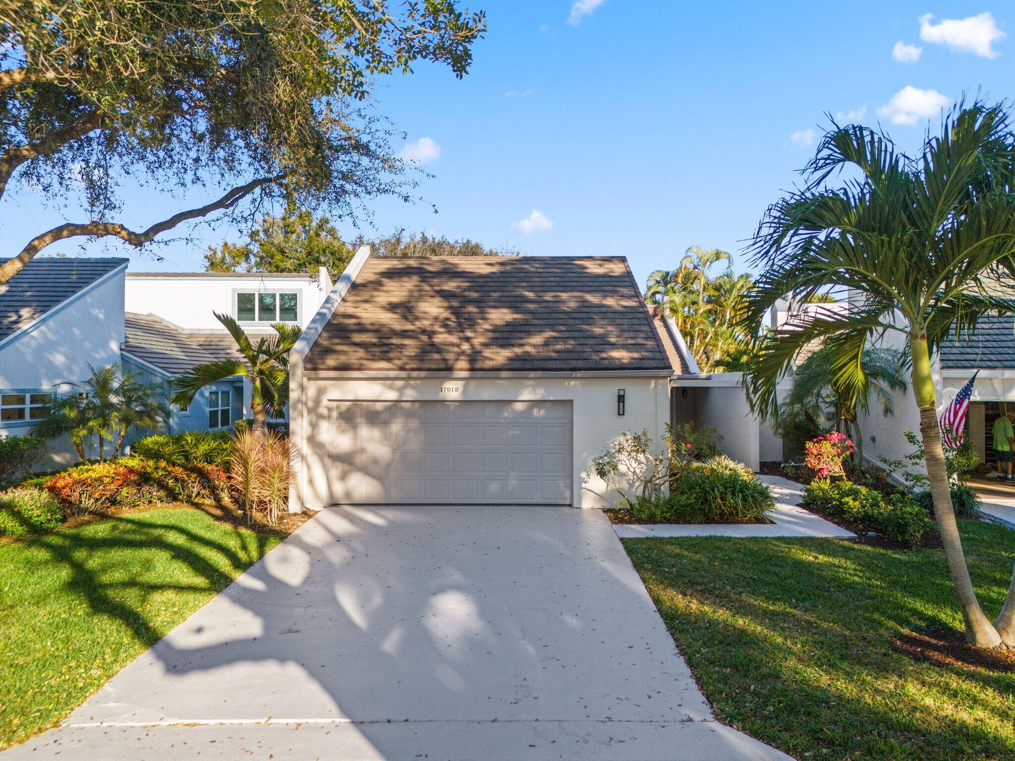 17012 Traverse Circle Jupiter, FL 33477 - Photo 31 of 33 a front view of a house with a yard and potted plants