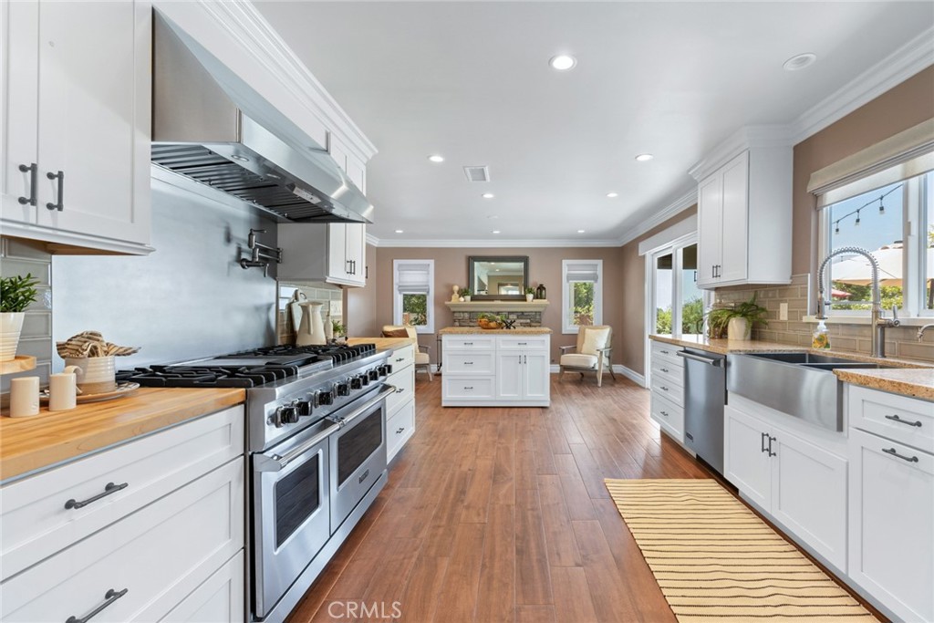 1940 Sunset Lane Fullerton, CA 92833 - Photo 16 of 50 a large kitchen with stainless steel appliances granite countertop a stove oven a sink dishwasher and white cabinets with wooden floor