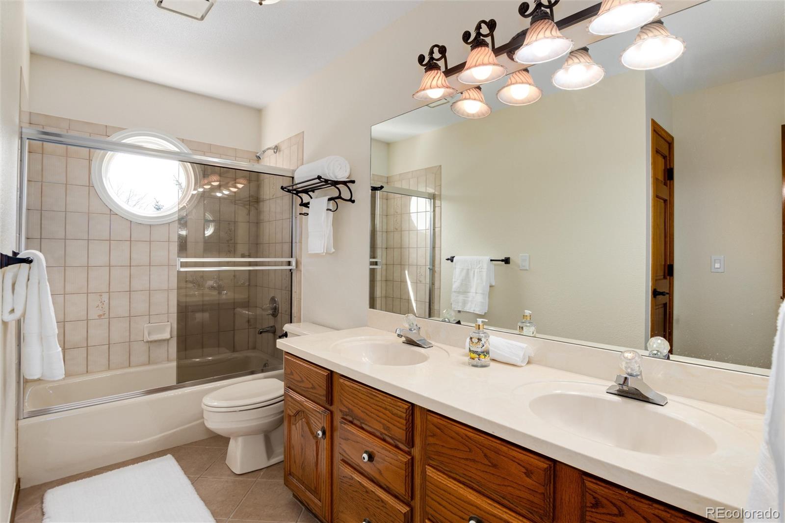 65 North Ranch Road Littleton, CO 80127 - Photo 20 of 44 a bathroom with a sink vanity granite toilet and shower