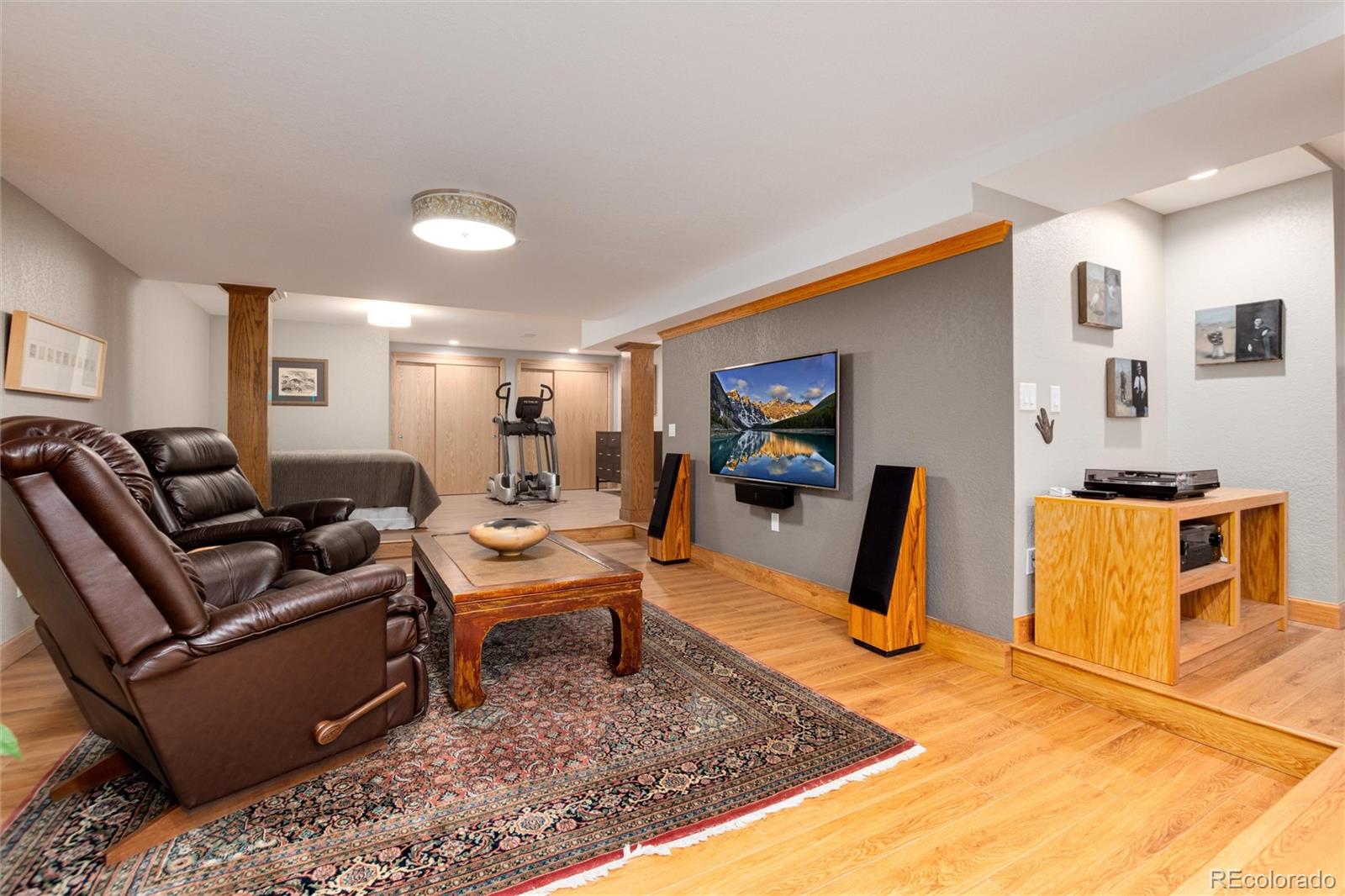 65 North Ranch Road Littleton, CO 80127 - Photo 24 of 44 a living room with furniture a flat screen tv and a table