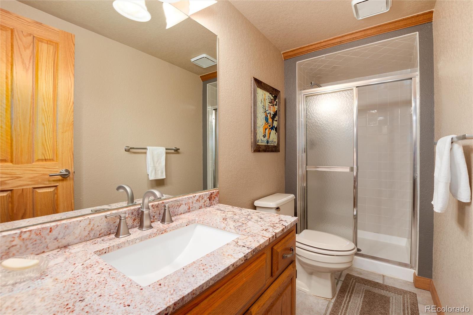 65 North Ranch Road Littleton, CO 80127 - Photo 29 of 44 a bathroom with a granite countertop sink toilet and shower