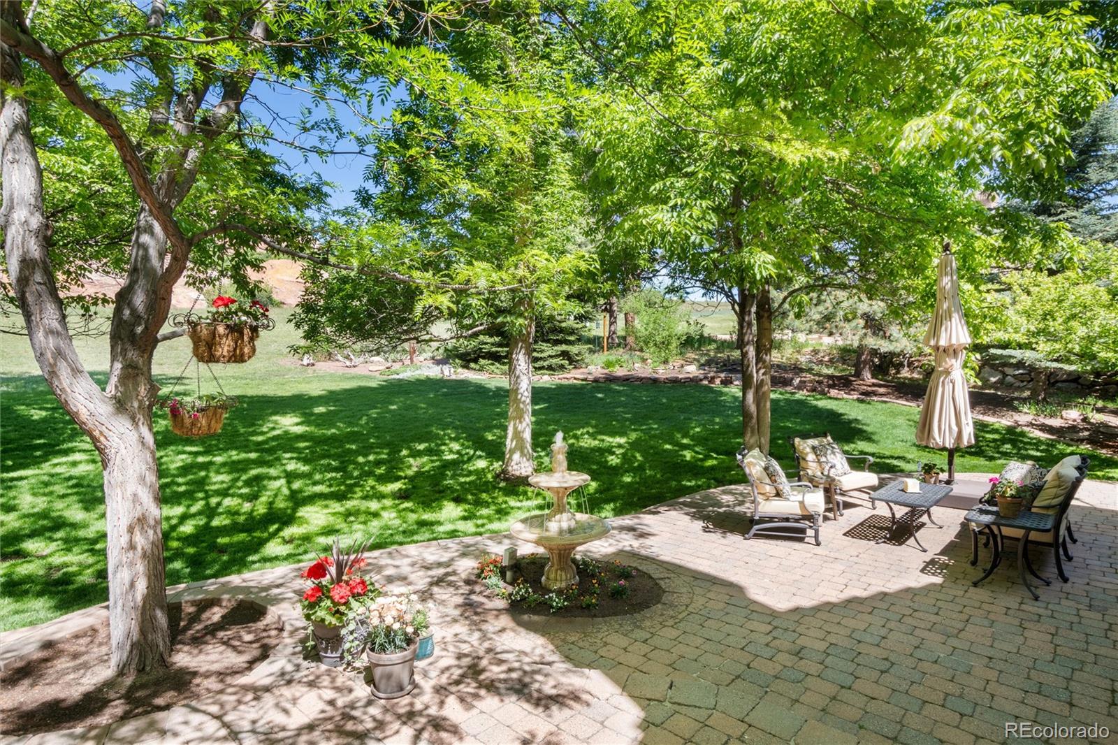 65 North Ranch Road Littleton, CO 80127 - Photo 30 of 44 a view of a patio with table and chairs potted plants and large tree