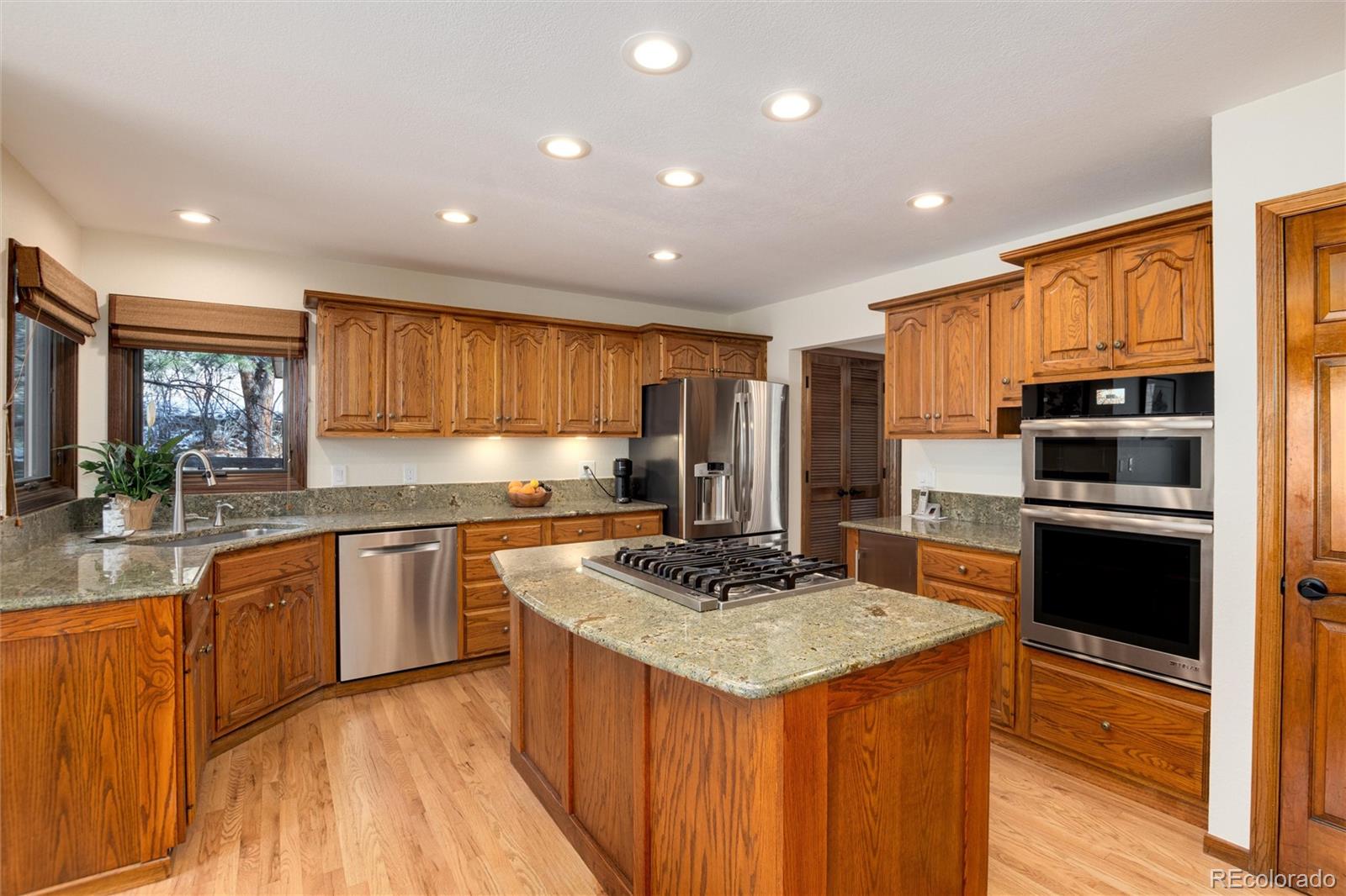 65 North Ranch Road Littleton, CO 80127 - Photo 8 of 44 a kitchen with stainless steel appliances granite countertop a stove refrigerator sink and cabinets