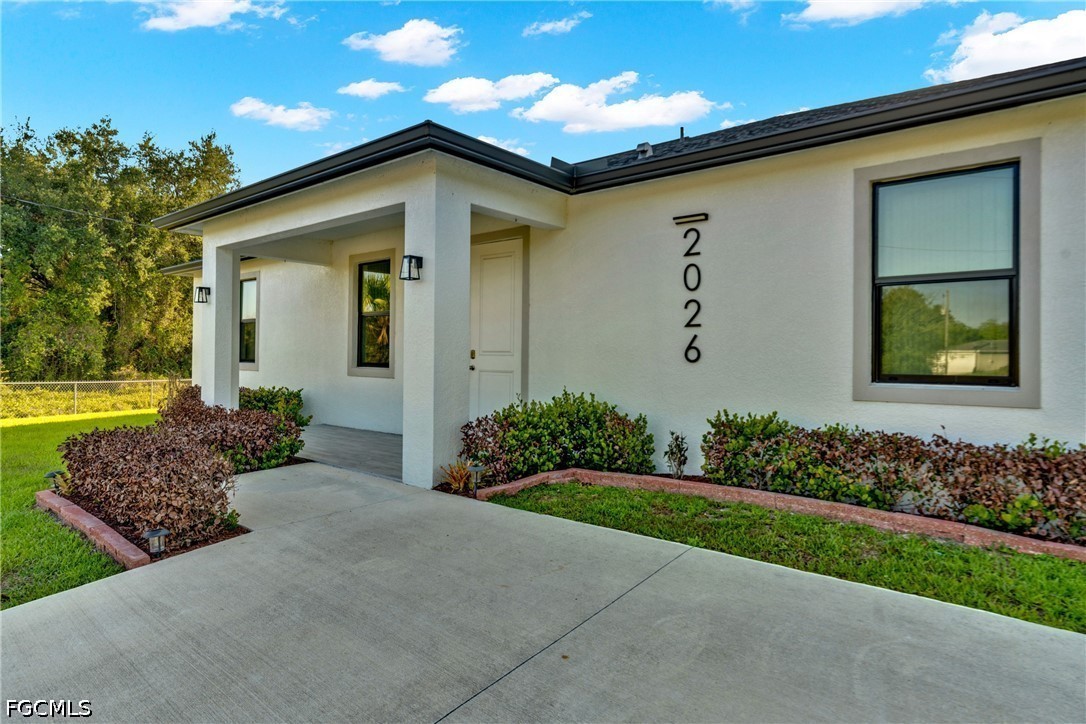 2026 Jeronimo Road LaBelle, FL 33935 - Photo 2 of 15 a front view of a house with garden