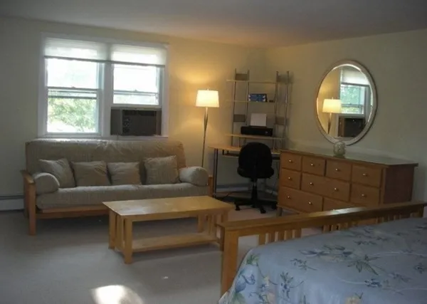 a living room with furniture a mirror and a large window