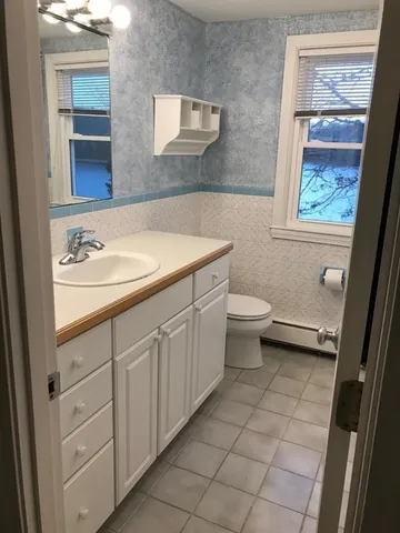 a bathroom with a sink a toilet and a mirror