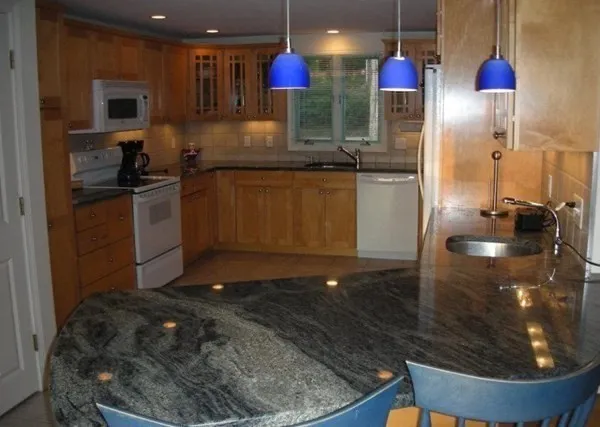 a kitchen with granite countertop a sink a stove and refrigerator