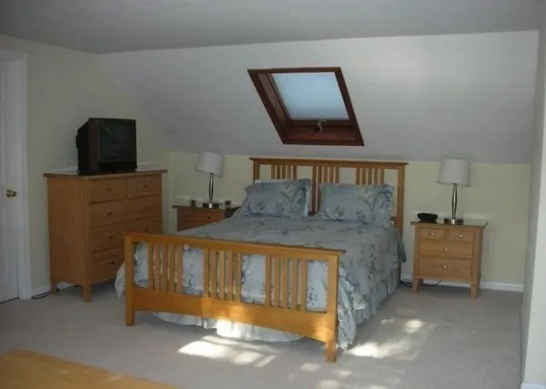 a bed sitting in a room next to a lamp next to a window