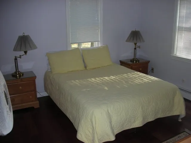 a bed sitting in a bedroom next to a window