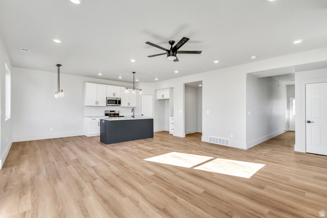 547 North Hvn Drive Mapleton, UT 84664 - Photo 23 of 23 Kitchen featuring open floor plan, white cabinetry, ceiling fan, and light wood-style floors