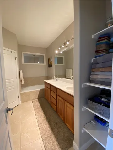 a spacious bathroom with a double vanity sink a mirror and a shower