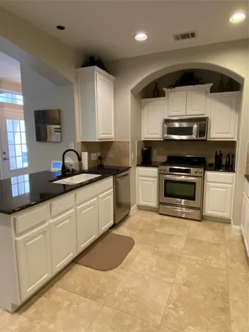 a kitchen with a sink a microwave and cabinets