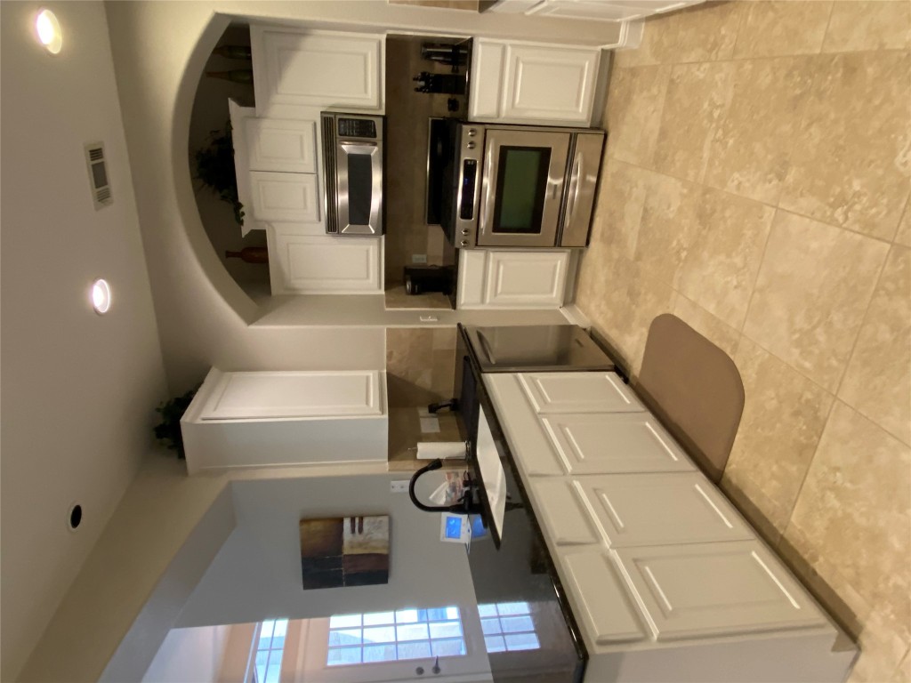 3406 Menchaca Road, Unit 24 Austin, TX 78704 - Photo 4 of 14 a kitchen with a sink a microwave and cabinets