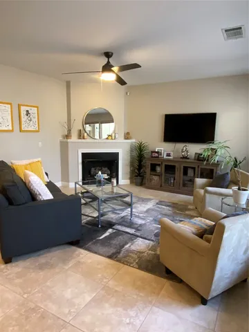 a living room with furniture a flat screen tv and a fireplace