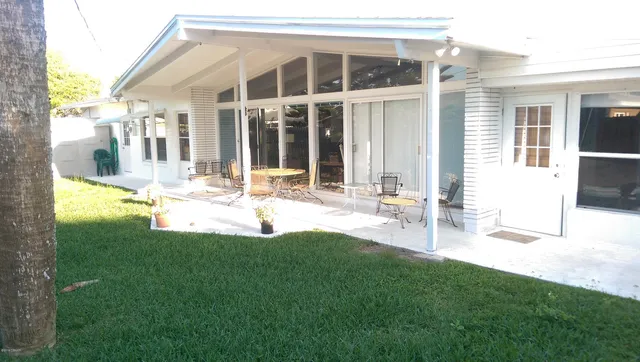 a view of backyard with table and chairs and wooden fence