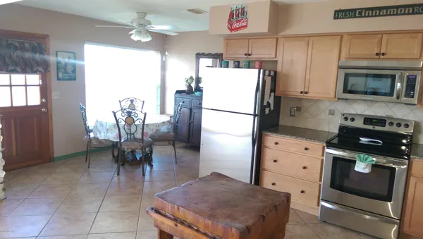 a kitchen with a refrigerator a stove a microwave and a dining table