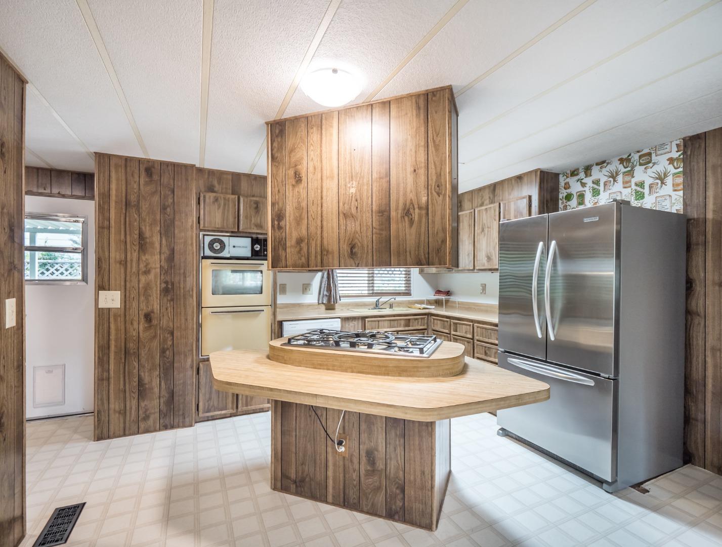 270 Hames Road, Unit 60 Corralitos, CA 95076 - Photo 6 of 32 a kitchen with kitchen island stainless steel appliances a refrigerator stove microwave and cabinets