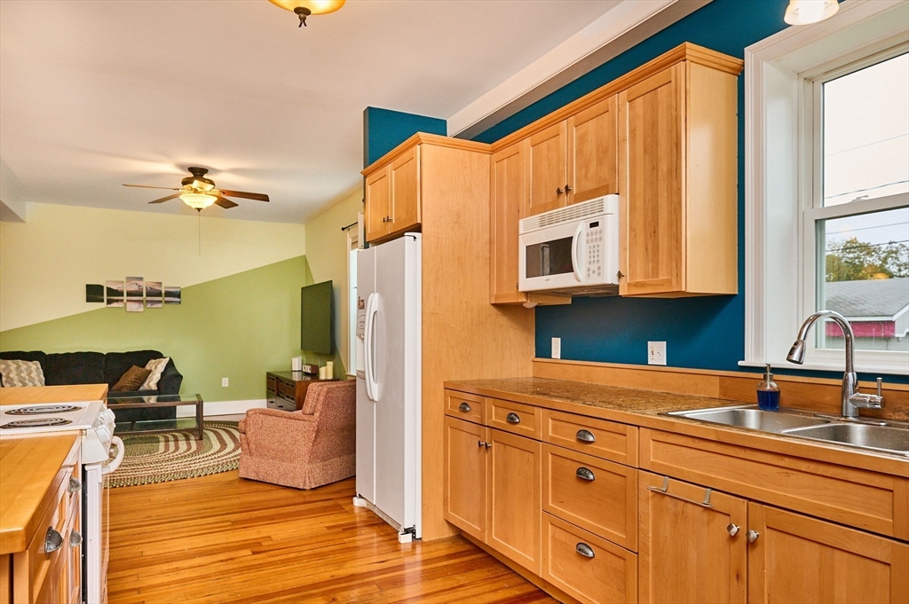 12 A Parker Avenue, Unit 1 Northfield, MA 01360 - Photo 6 of 28 a living room with stainless steel appliances furniture a fireplace and a large window