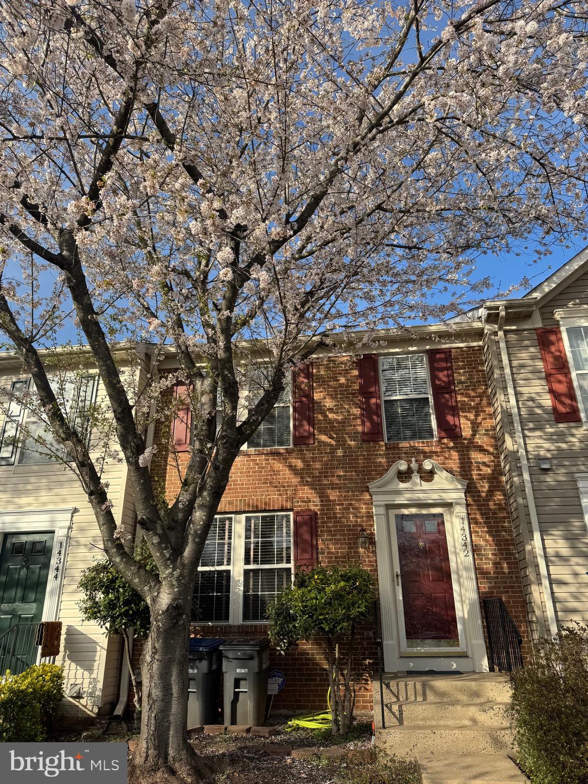 a front view of a building with large trees