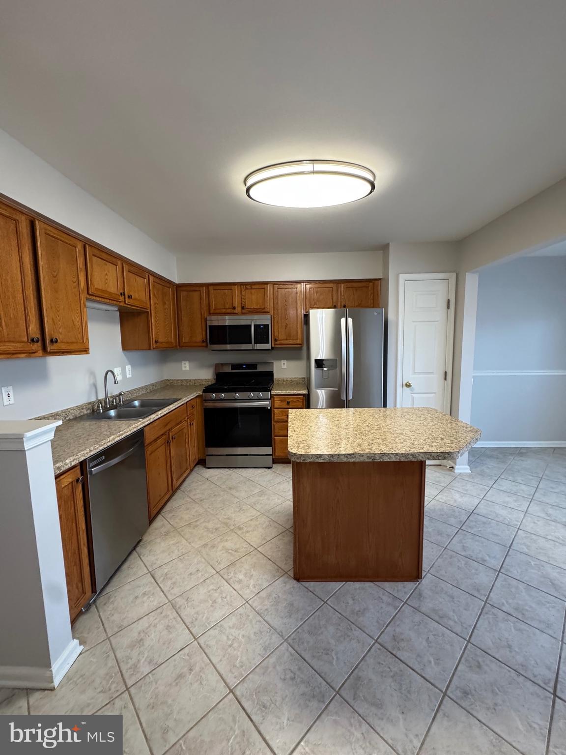 14342 Papilion Way Centreville, VA 20121 - Photo 14 of 46 a large kitchen with granite countertop a stove a sink dishwasher and a refrigerator