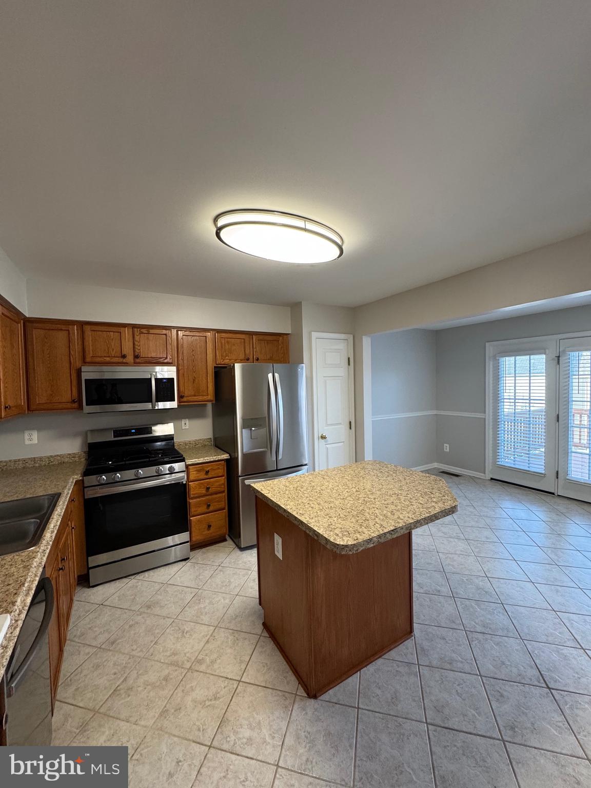 14342 Papilion Way Centreville, VA 20121 - Photo 25 of 46 a kitchen with stainless steel appliances granite countertop a stove a sink and a refrigerator