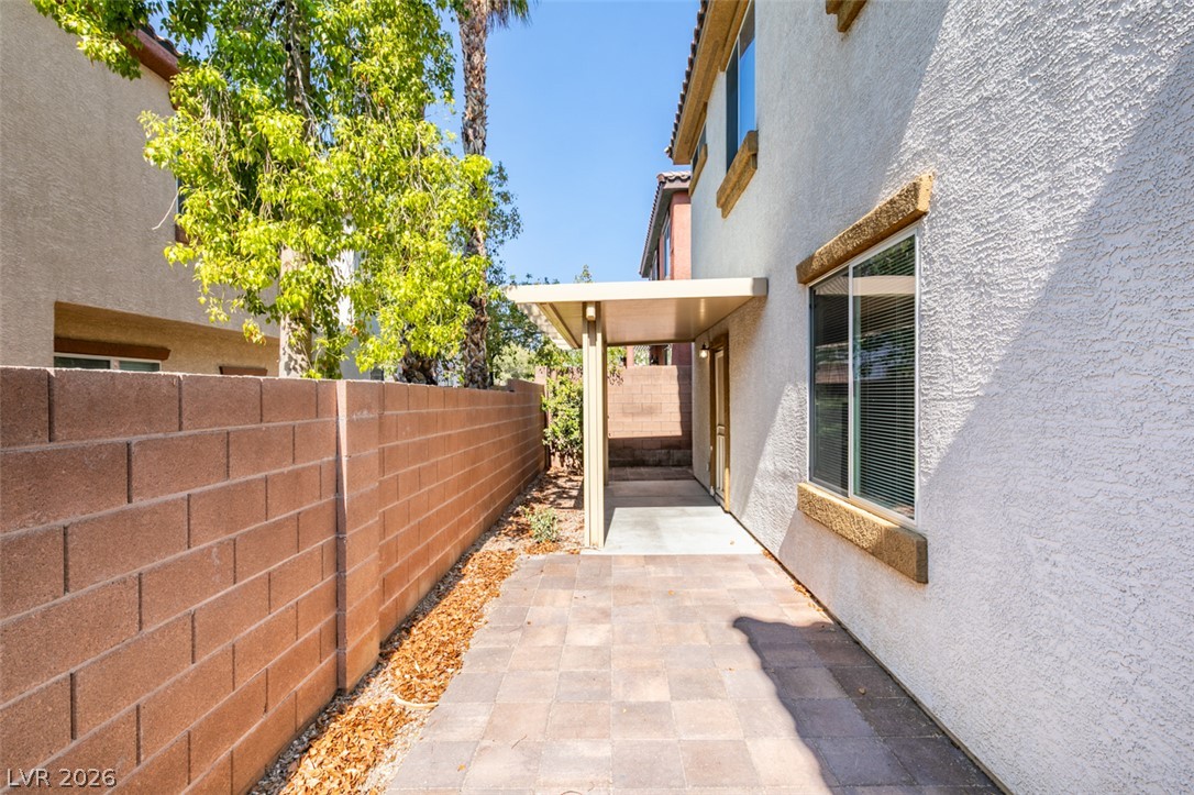 8937 Caledon Ridge Court Las Vegas, NV 89149 - Photo 41 of 43 A private side patio featuring durable paver flooring and a protective awning offers a serene outdoor retreat.