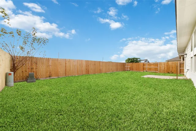 a view of yard with grass and wooden fence