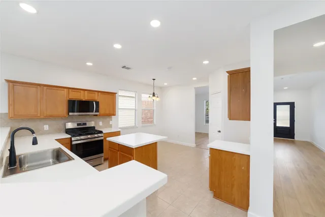 a kitchen with stainless steel appliances granite countertop a sink a stove and a refrigerator